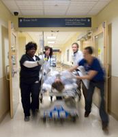 patient on gurney being rushed through hallway