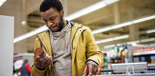 Man looking at food label grocery store