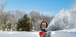 Man pushing snowblower in snow