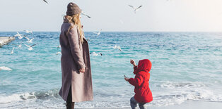 Mother and child on beach in winter