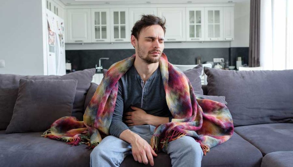 Man on couch with stomach bug