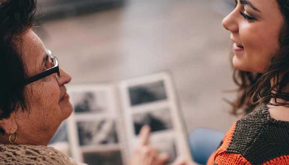 grand mother and daughter looking at photo album