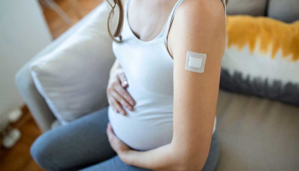 Pregnant women with band aid on arm