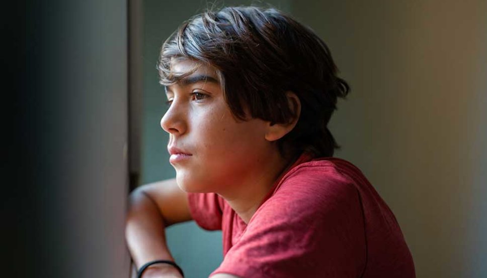 Latinx youth looking out window