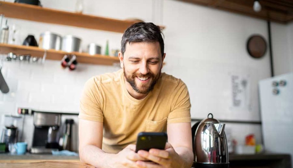 Man looking at phone in kitchen