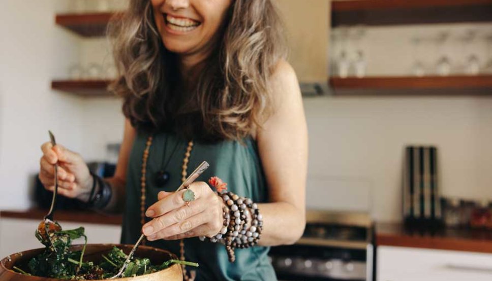Women making salad and smiling