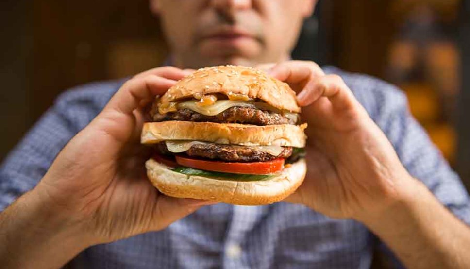 Man eating fast food cheese burger