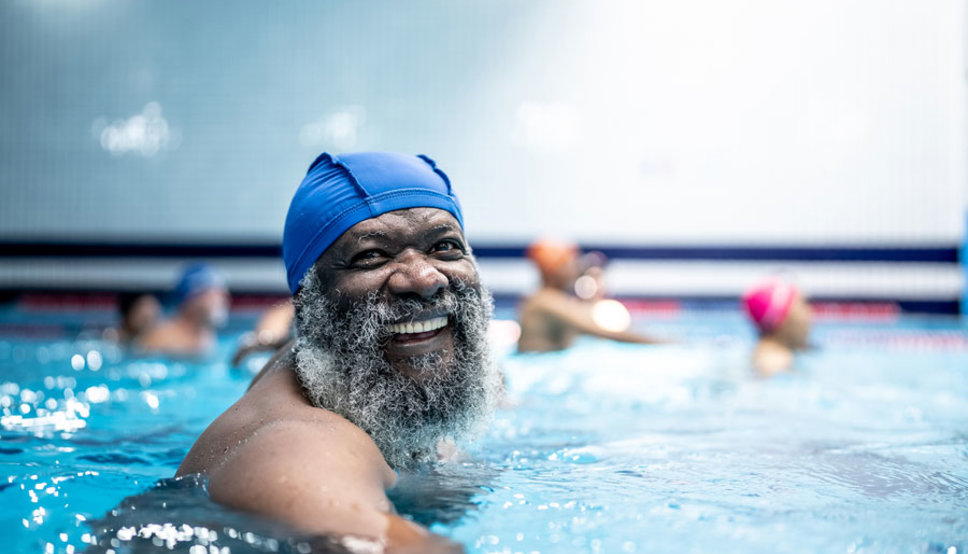 Man swimming in pool smiling
