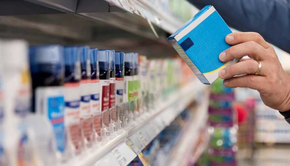 Person looking at ingredients of cold medicine in pharmacy