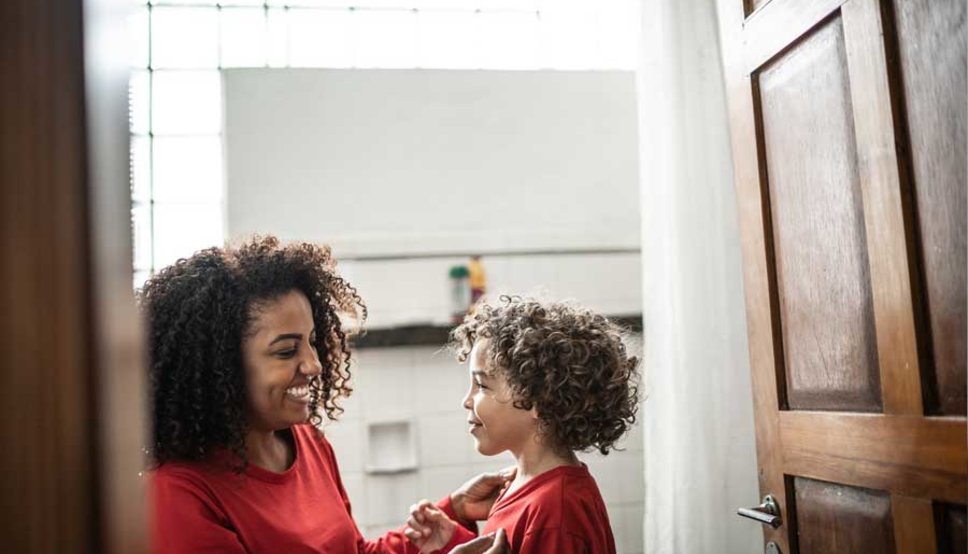 Mother and son in bathroom smiling