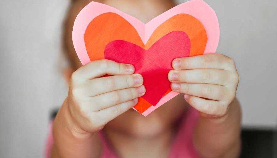 Little girl holding heart cut outs