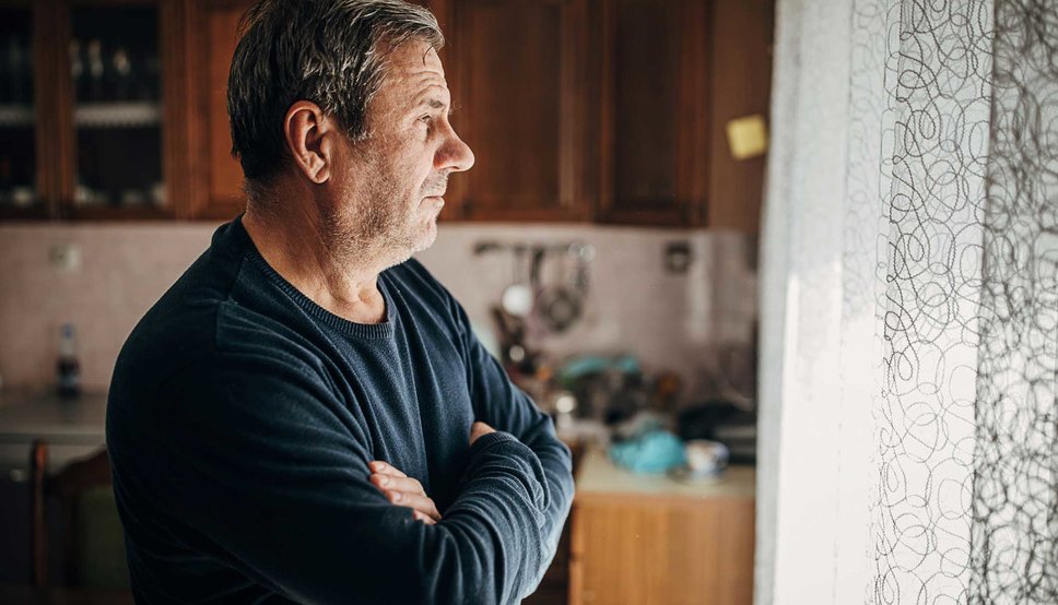 Concerned man looking out window