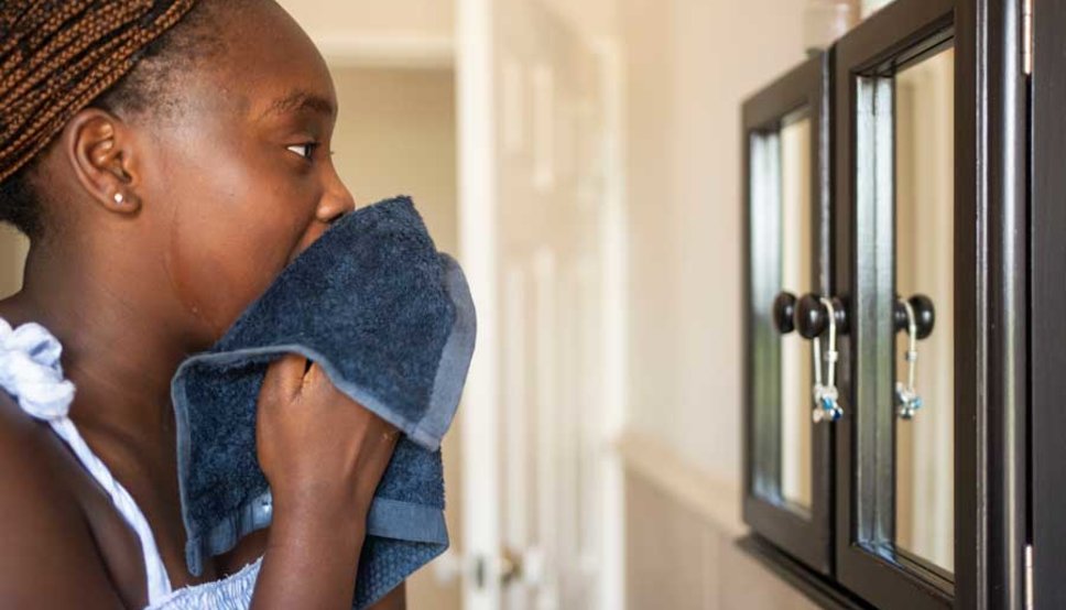 Teenager washing face in mirror