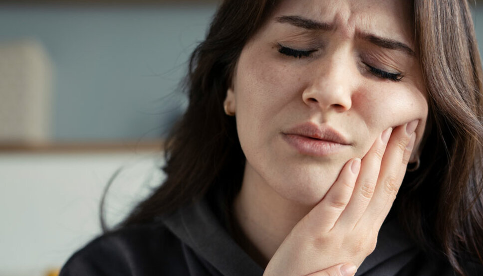 Women holding jaw in pain