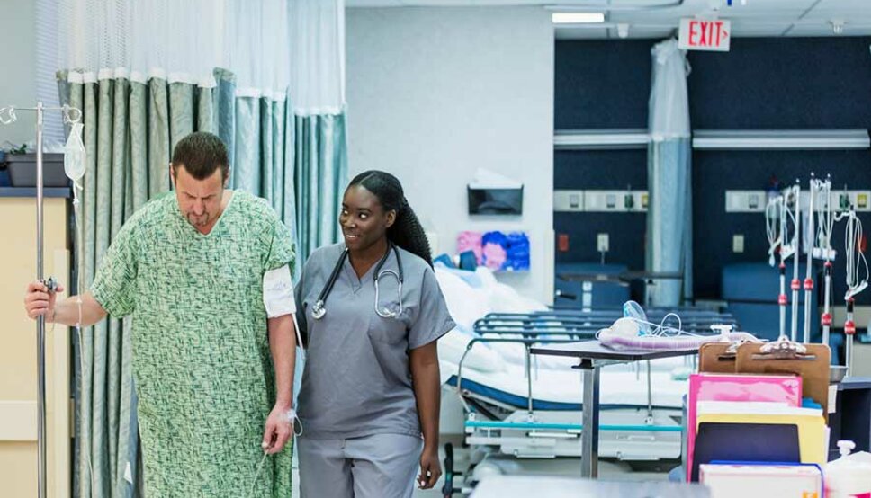 PAtient walking in hospital with health care worker