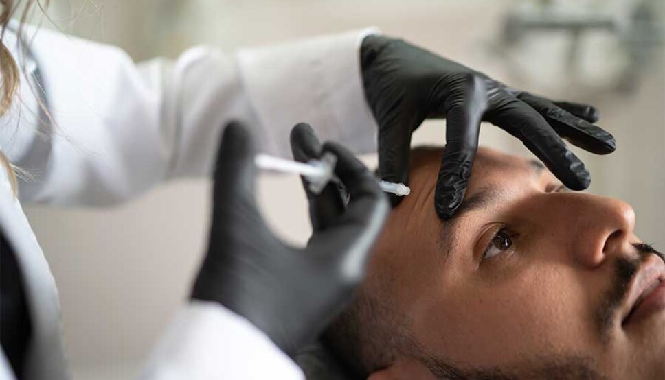 Man receiving botox injection in forehead