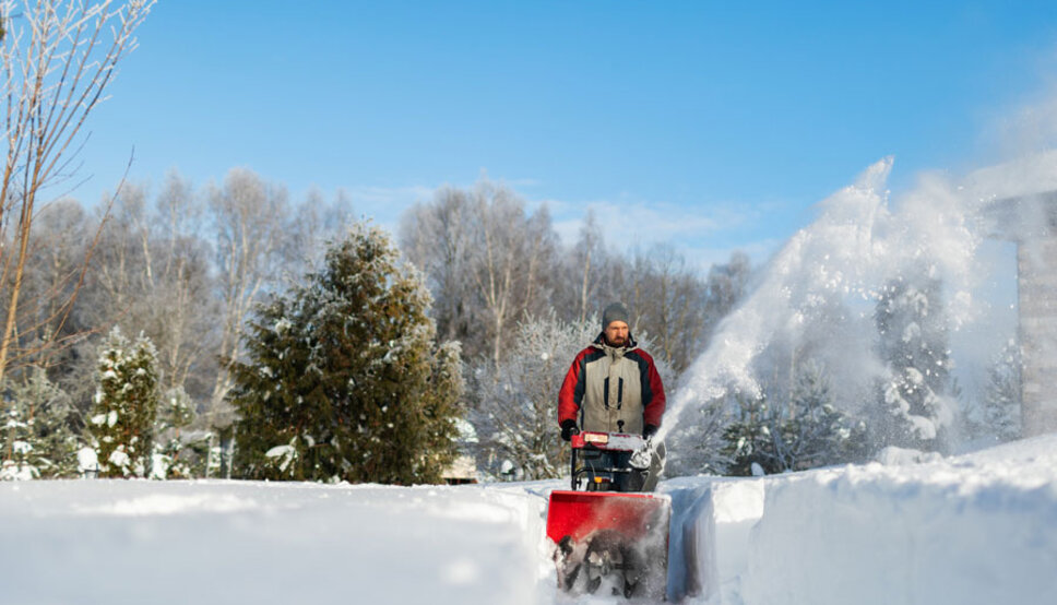 Man pushing snowblower in snow