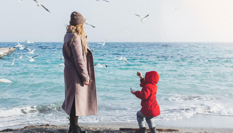 Mother and child on beach in winter