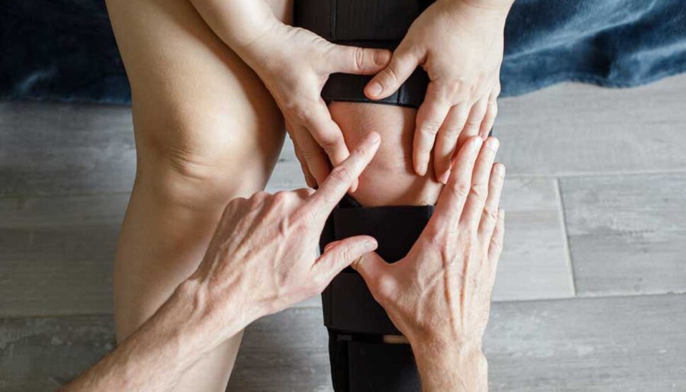 Person with knee brace and provider pointing to knee