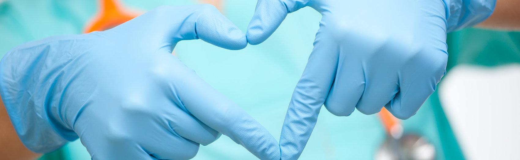 Nurse making a heart symbol with gloved hands