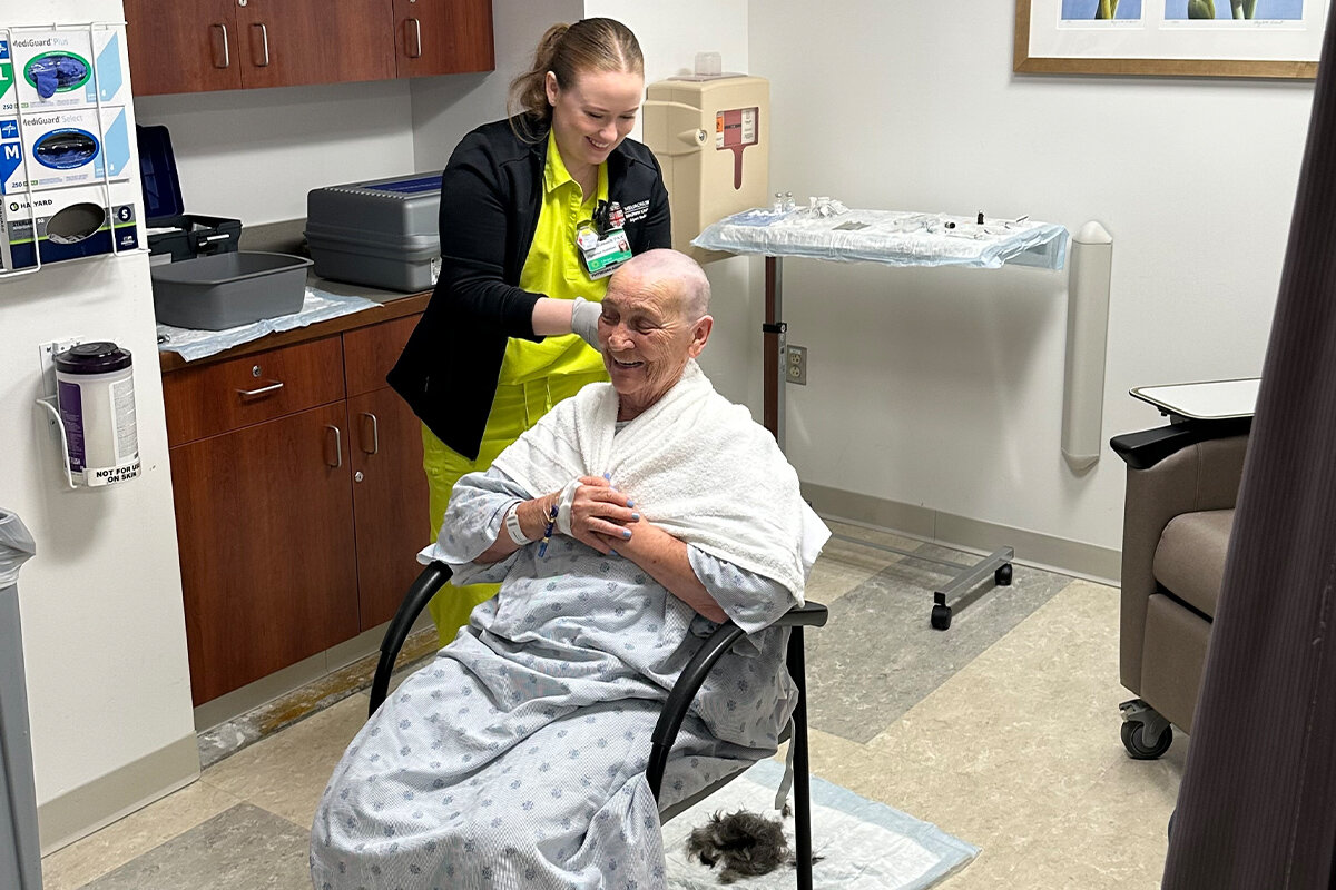 A technician shaves Rita Dennis's scalp.