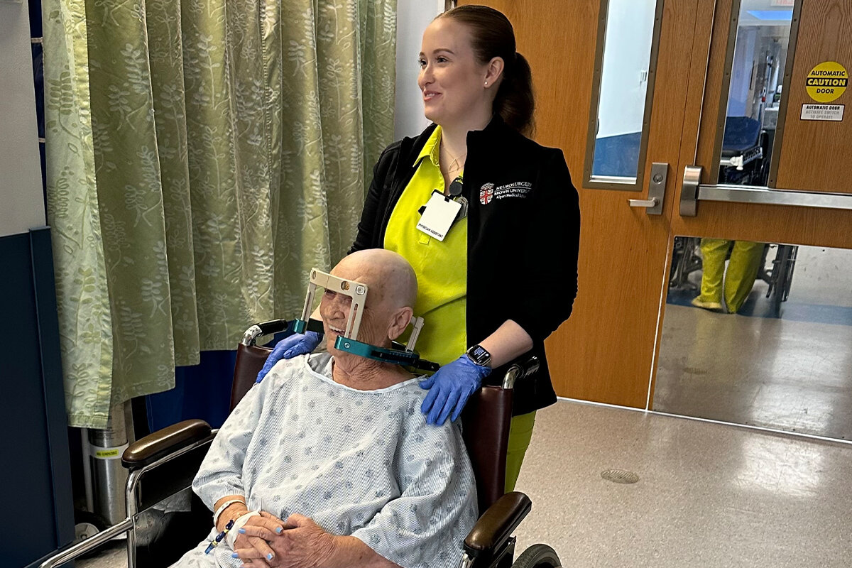 A technician uses a wheelchair to bring Rita Dennis to treatment.