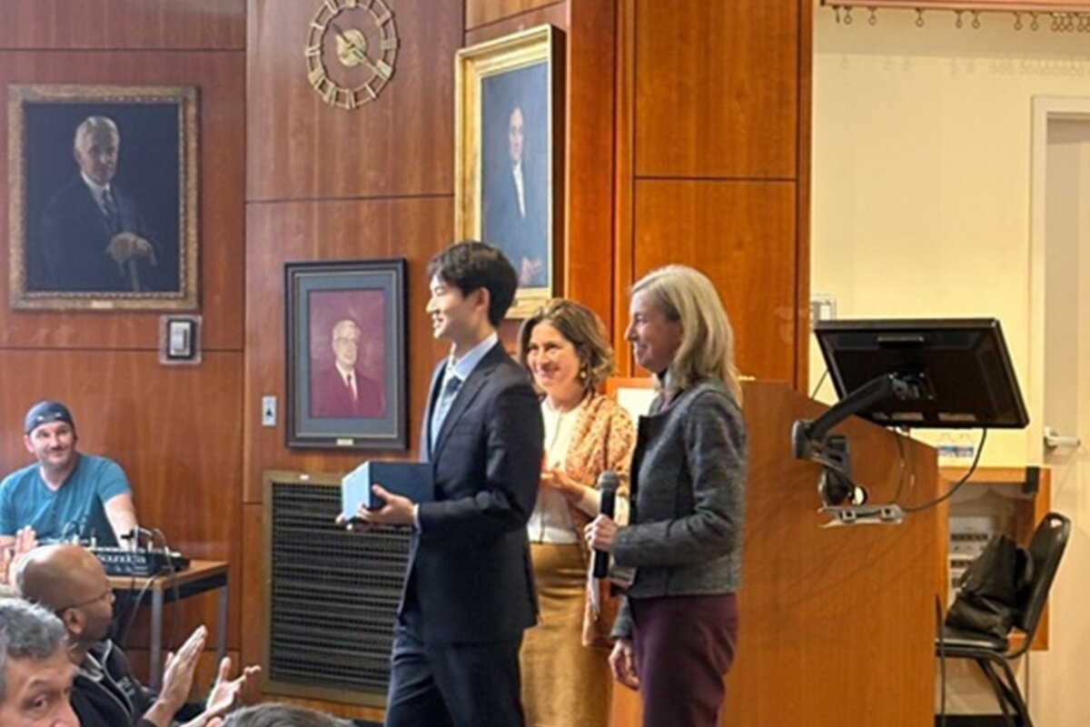 Award recipient showing award to attendees