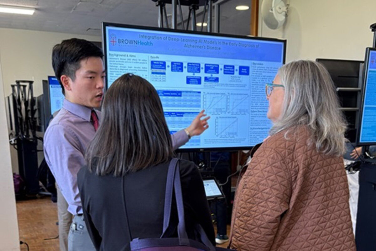 Group of three attendees discussing digital poster