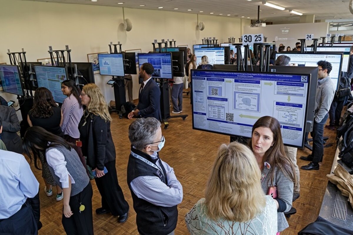 Panned out shot of digital posters and attendees