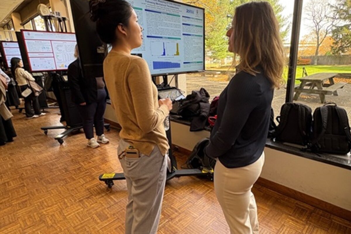 Two attendees discuss poster