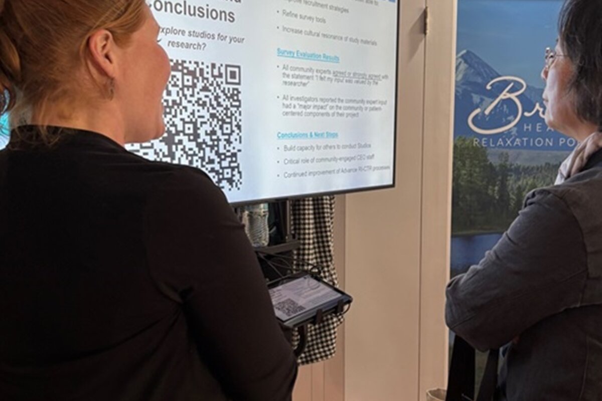 Two attendees viewing poster with QR Code