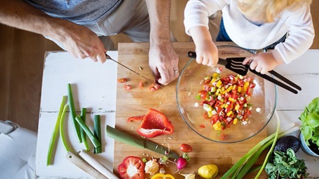 adult chopping vegetables with child