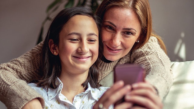Mother and daughter looking at a cell phone