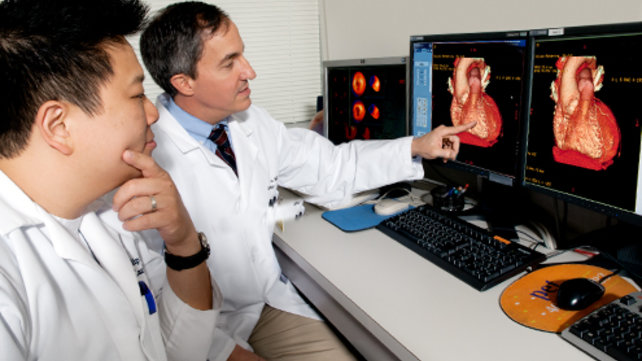 Two medical technicians examine imaging results.
