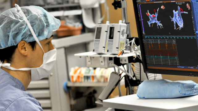 A medical technician looks at medical scans.
