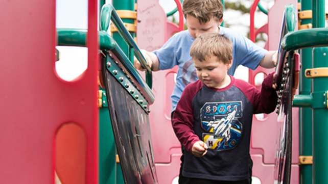 Two brothers playing on a playset