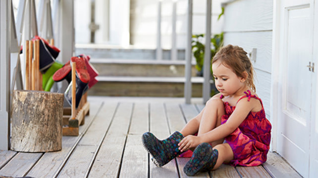 girl putting on rain boots