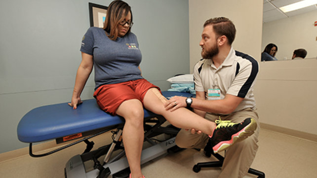 Woman having her knee examined