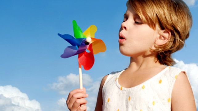 girl blowing on pinwheel