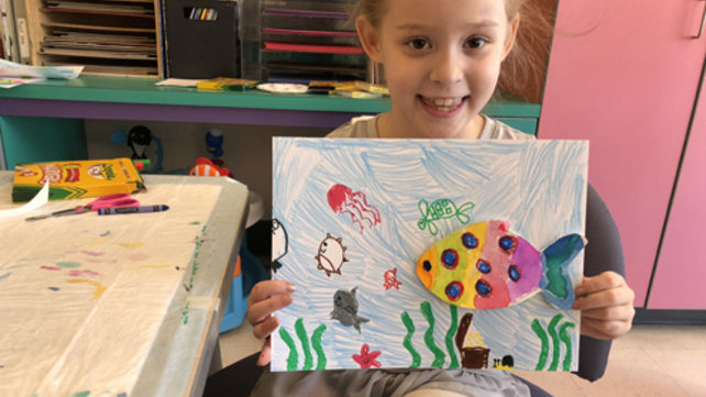 girl holding up drawing