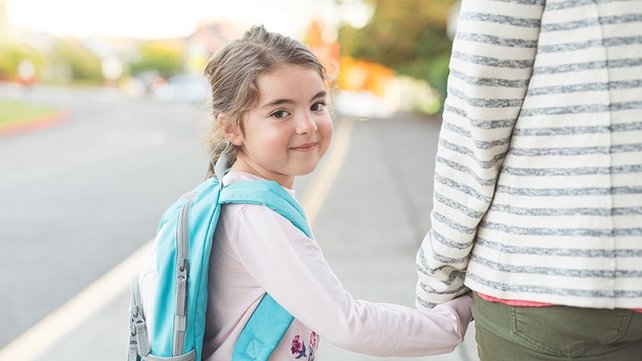 Young girl walking with parent