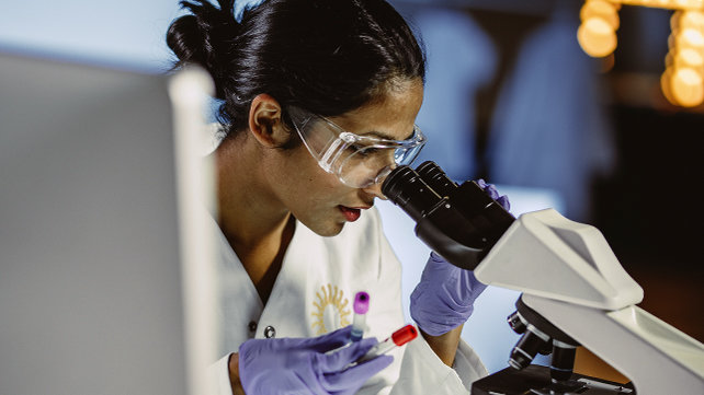 Medical staff using a microscope for research