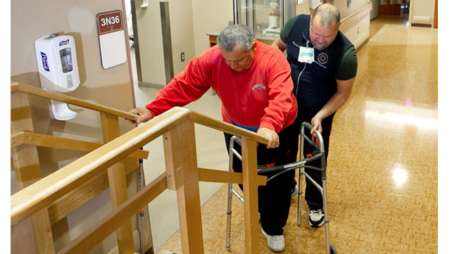 A man practices climbing stairs after surgery.