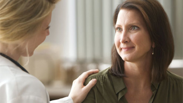woman patient with doctor's hand on shoulder