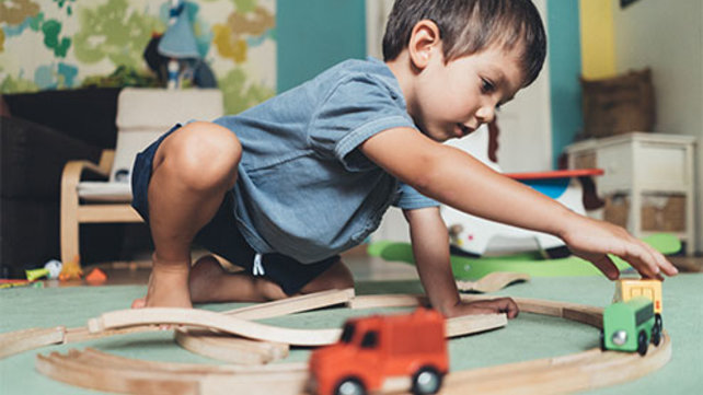 Child playing with toy cars and trucks