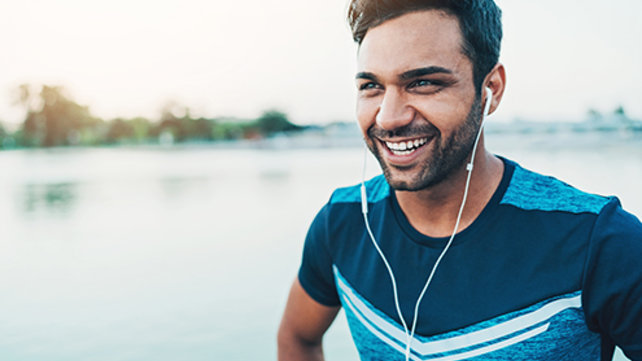 Smiling man wearing ear buds