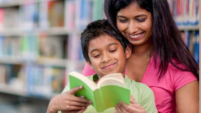 Woman and child reading a book together