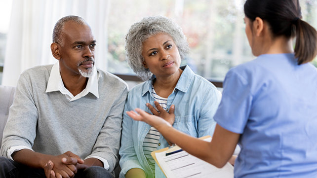 African American couple speaking with a female doctor.