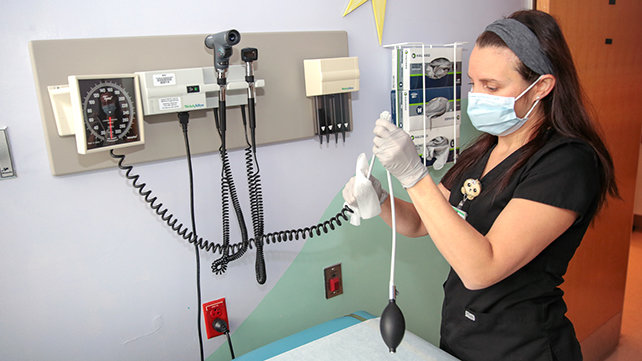 A medical technicians readies equipment.