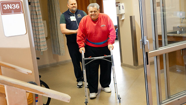 Man in red shirt using walker
